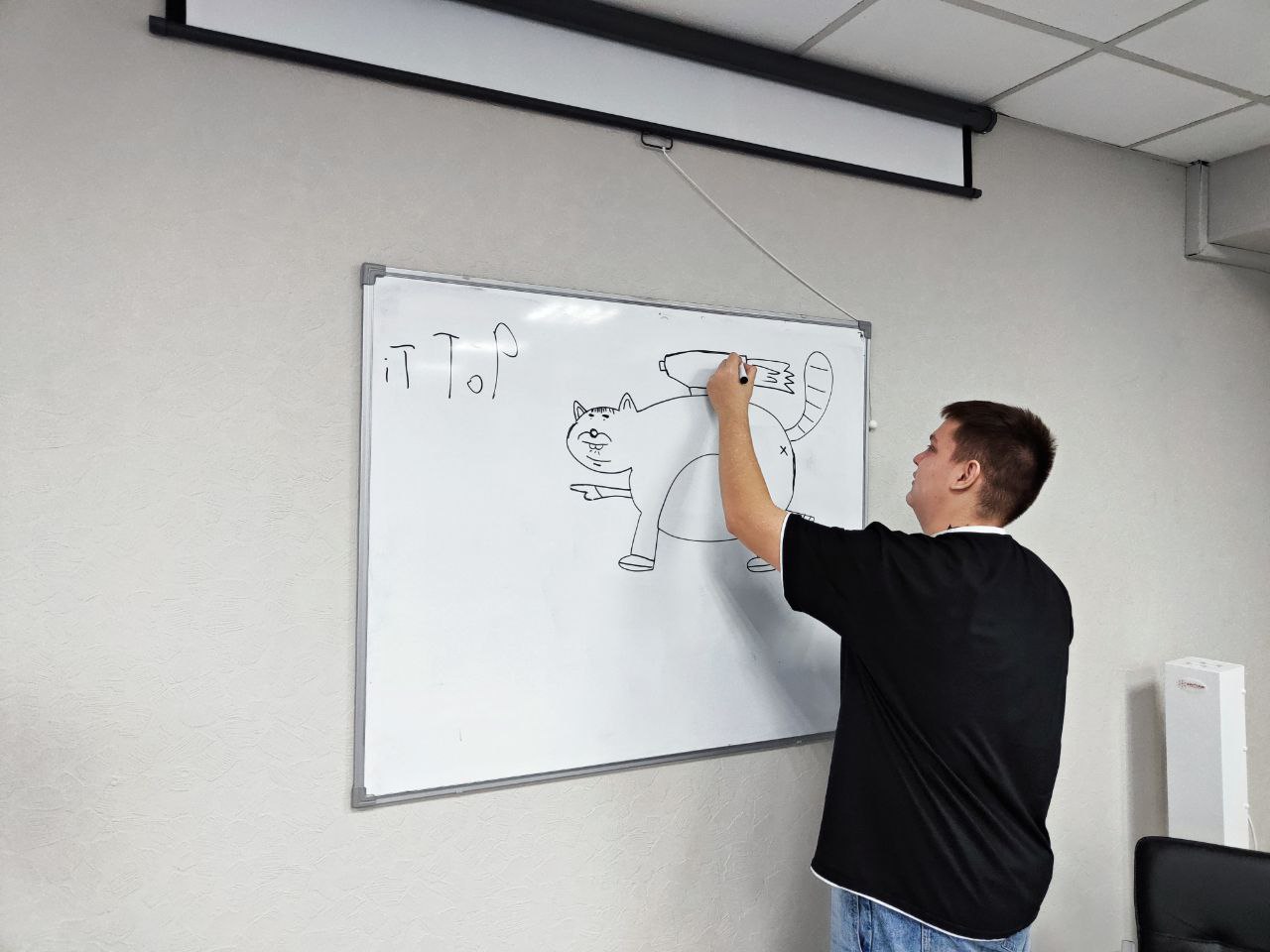 Студент рисует на доске в перерыве